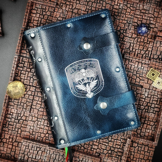 Handmade A5 leather adventure journal featuring a hand-gilded Ravenclaw eagle crest, Marauder's Map footprints, and a wand duel spine design by Grimbeard Leather