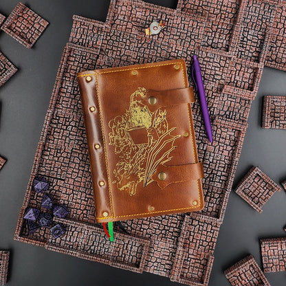 Handmade A5 leather adventure journal with hand-gilded wizard, dragon, and potion bottle design by Grimbeard Leather
