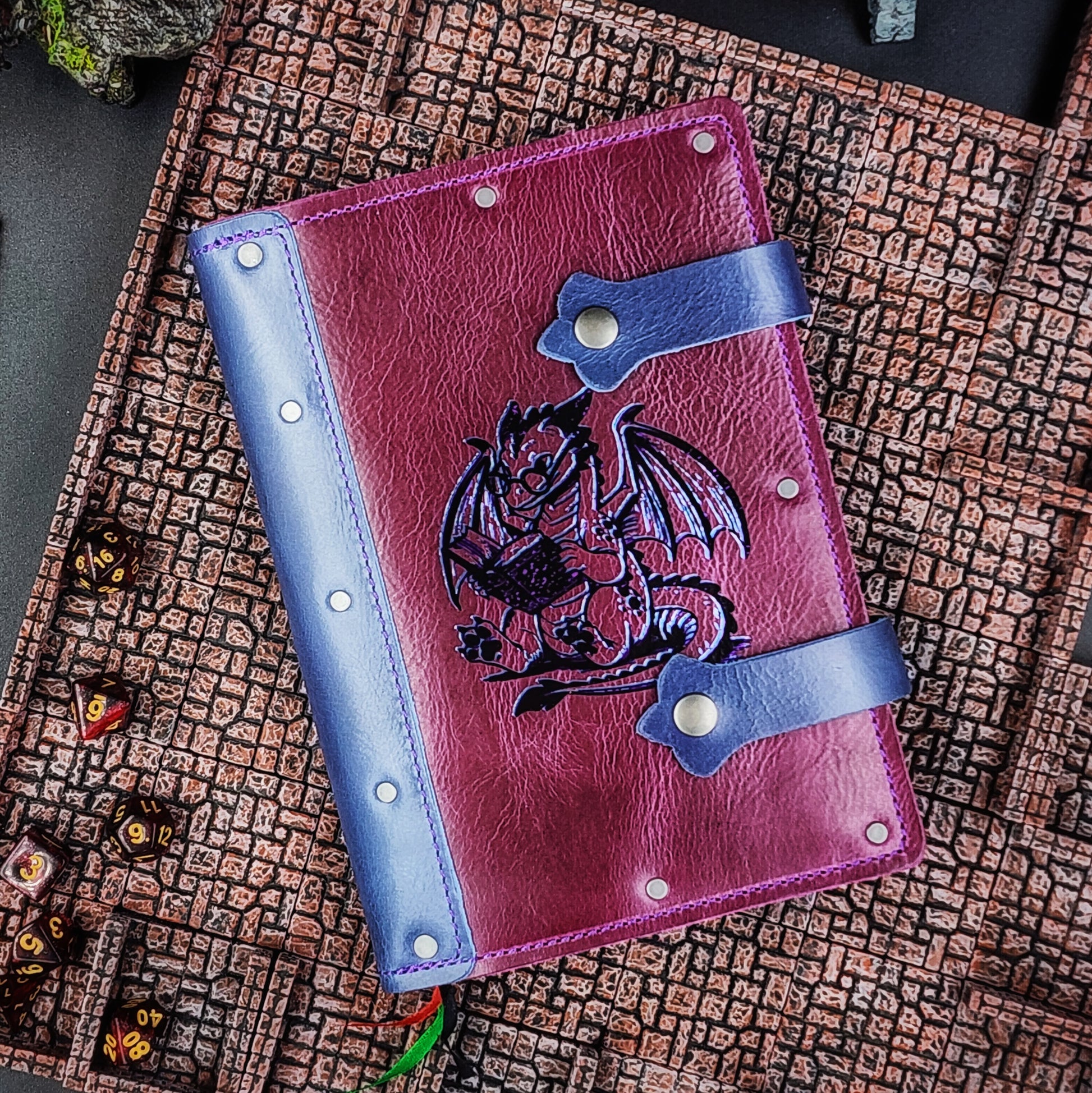Handmade A5 full-grain leather adventure journal with hand-gilded bookish dragon wearing glasses and reading design by Grimbeard Leather