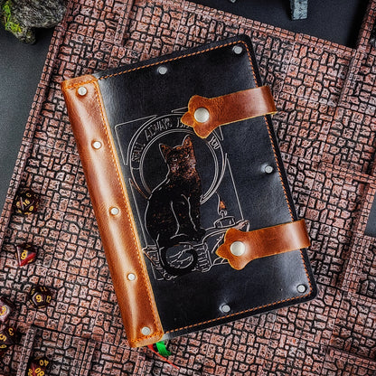 Handmade A5 leather adventure journal with hand-gilded black cat, candle, and "I shall always be with you" design by Grimbeard Leather