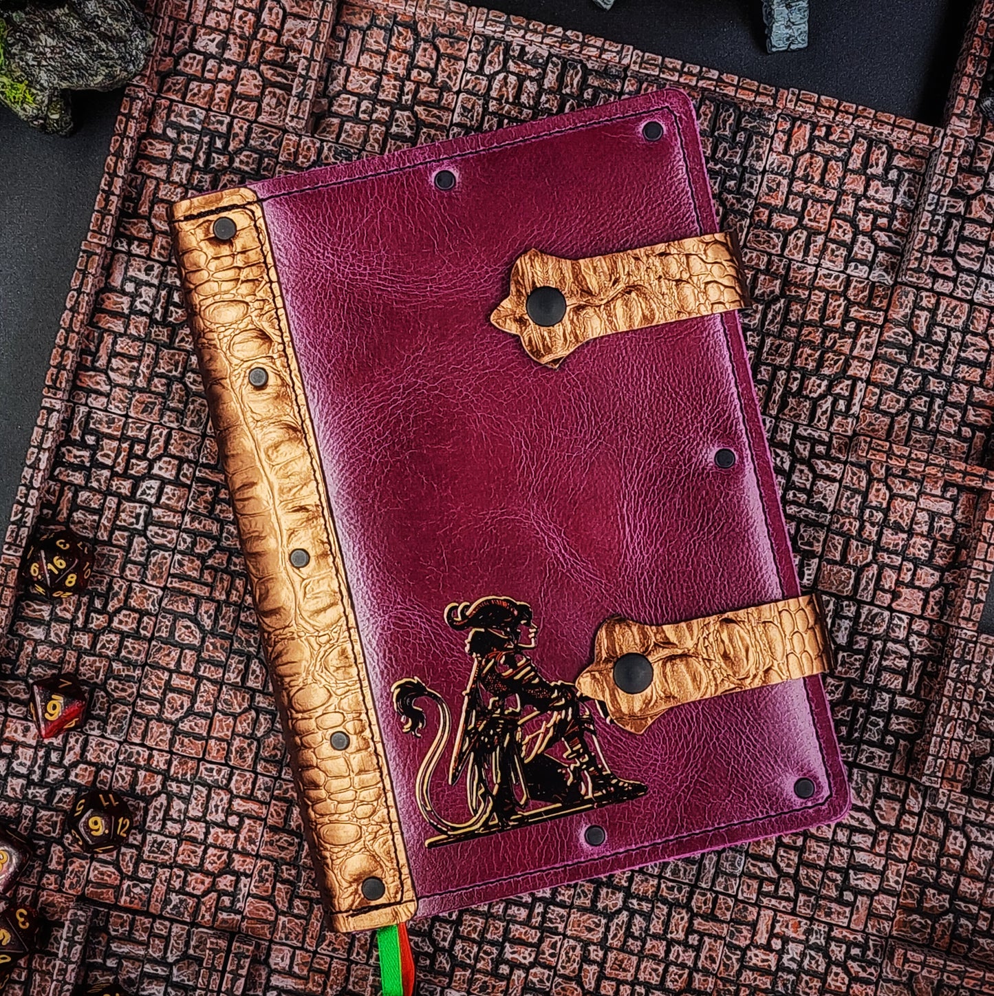 Handmade A5 leather adventure journal with hand-gilded seated tiefling character design by Grimbeard Leather