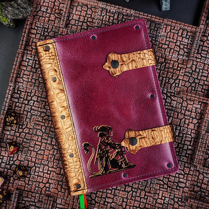 Handmade A5 leather adventure journal with hand-gilded seated tiefling character design by Grimbeard Leather