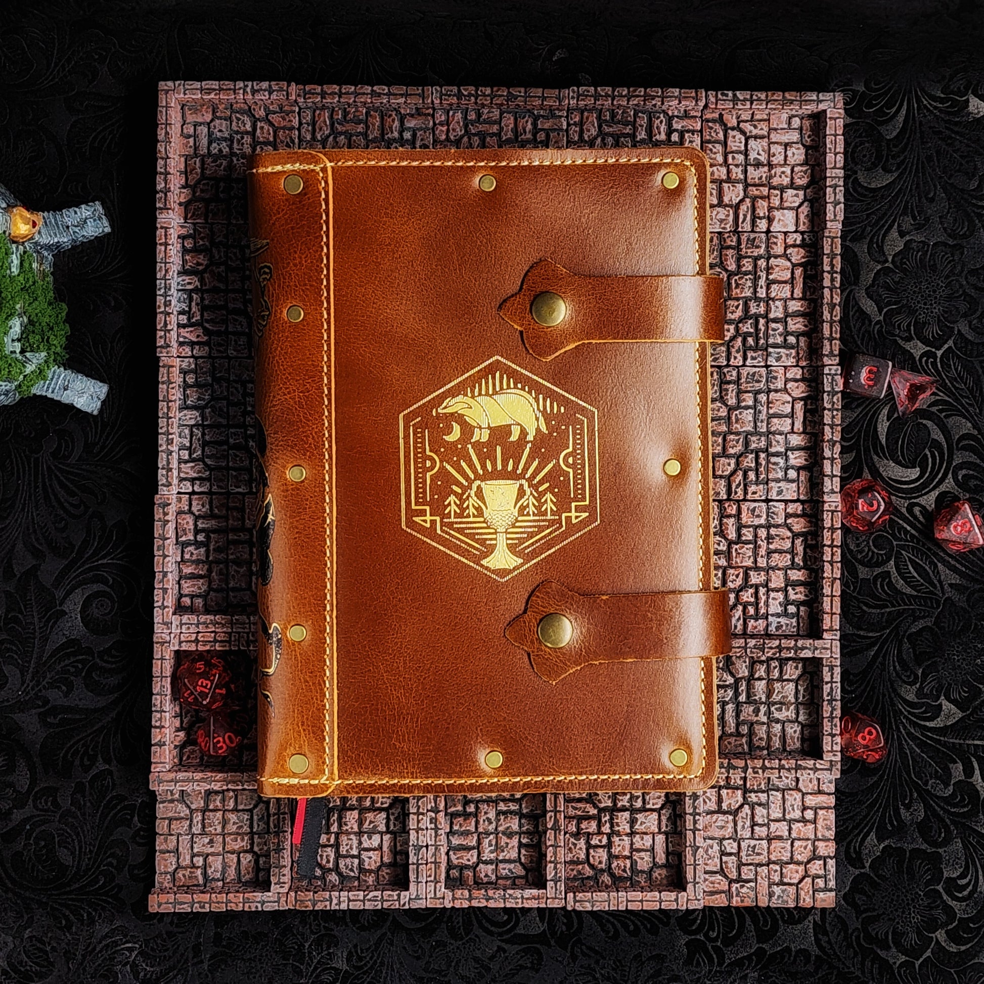 Handmade A5 leather adventure journal featuring a hand-gilded Hufflepuff badger crest, Marauder's Map footprints, and a wand duel spine design by Grimbeard Leather