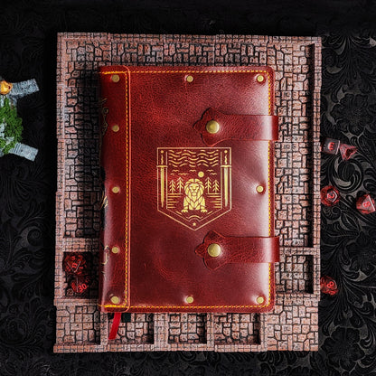 Handmade A5 leather adventure journal featuring a hand-gilded Gryffindor lion crest, Marauder's Map footprints, and a wand duel spine design by Grimbeard Leather